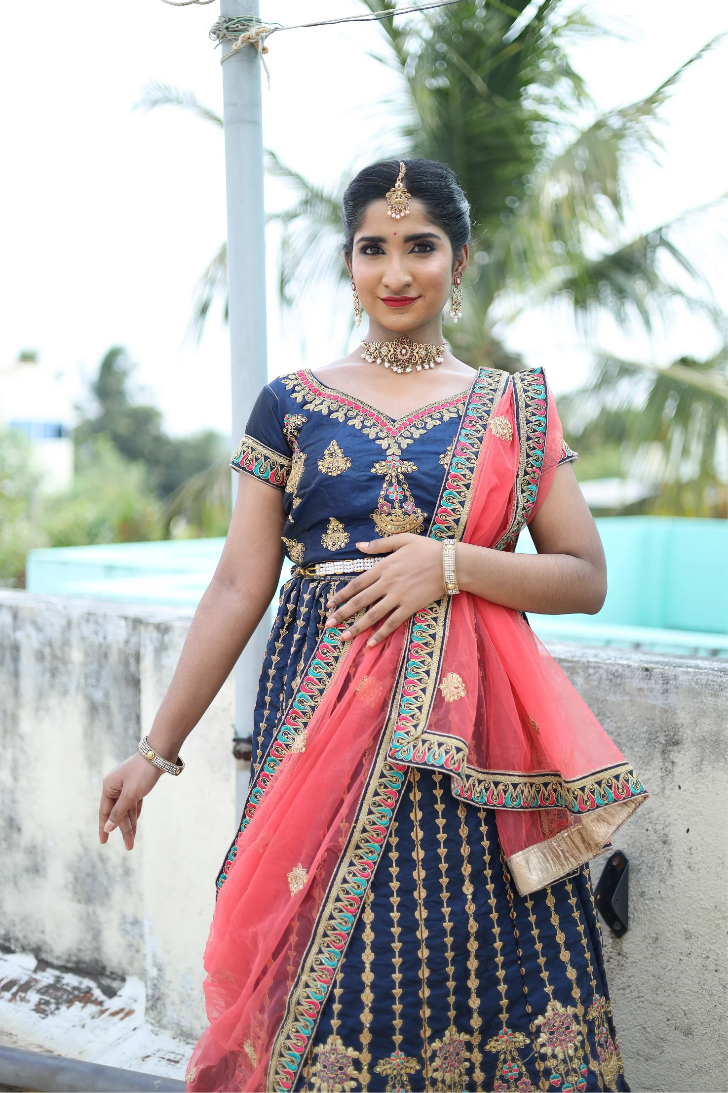 Full-length traditional bridal portrait in black and gold sari